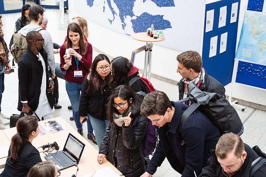 The arriving participants are registering in the entrance hall of the University